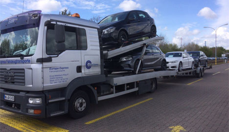 Vier Mercedes Benz transportieren